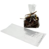 Clear cellophane side-gusset bag of chocolates tied with a gold raffia bow, next to an empty flat bag