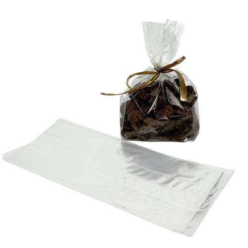 Clear cellophane side-gusset bag of chocolates tied with a gold raffia bow, next to an empty flat bag