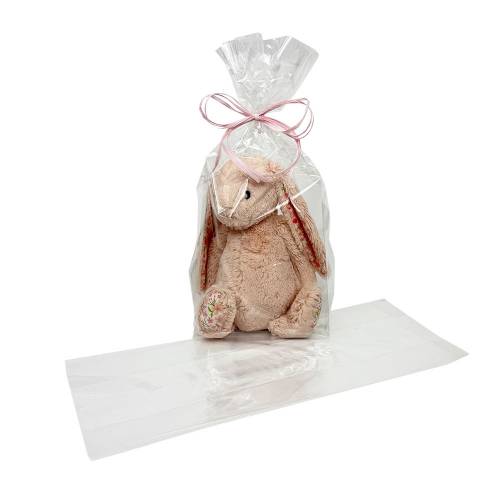 Large clear cellophane side-gusset bag holding a plush bunny tied with pink ribbon, next to an empty flat bag