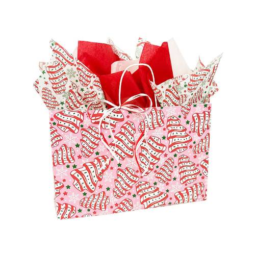 Wide pink paper shopping bag printed with frosted Christmas tree cakes, green and red stars and white snowflakes, and white twisted-paper handles