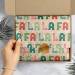 Fa La La Printed Tissue Paper - colorful holiday carol lettering with gold holly accents on a cream sheet