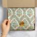 Floral Damask Pearl printed tissue paper lining a shipping box with a gold seal