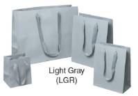 Light gray Manhattan shopping bags in matte uncoated paper with flat woven cotton-twill handles, shown in multiple sizes