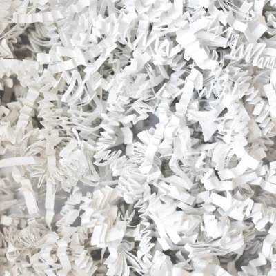 Close-up of white crinkle cut paper shred, crisp bright white zig-zag paper strands for gift basket and box fill