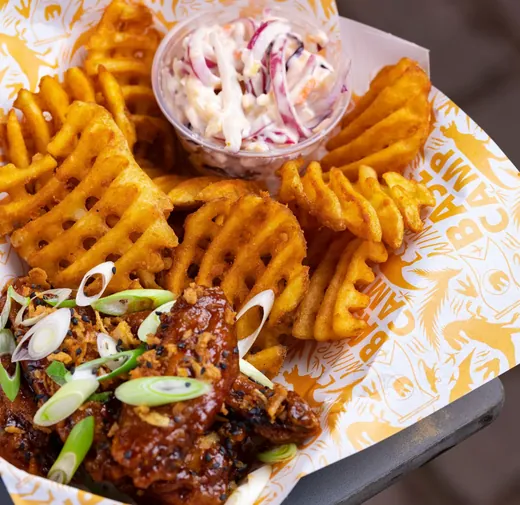 Waffle fries in a basket lined with branded paper