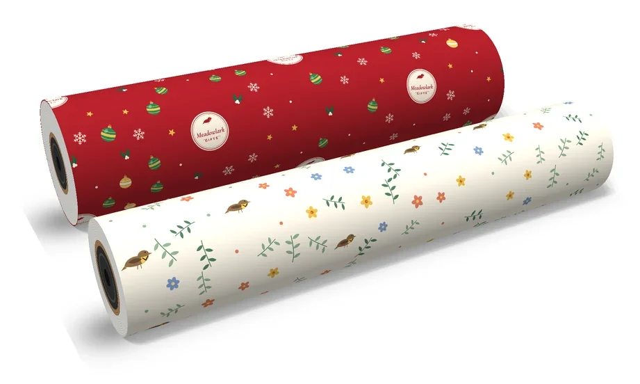 Two custom printed gift wrap counter rolls, a full ream in a red holiday print and a half ream in a cream floral print, showing the paper layers and core on the roll ends