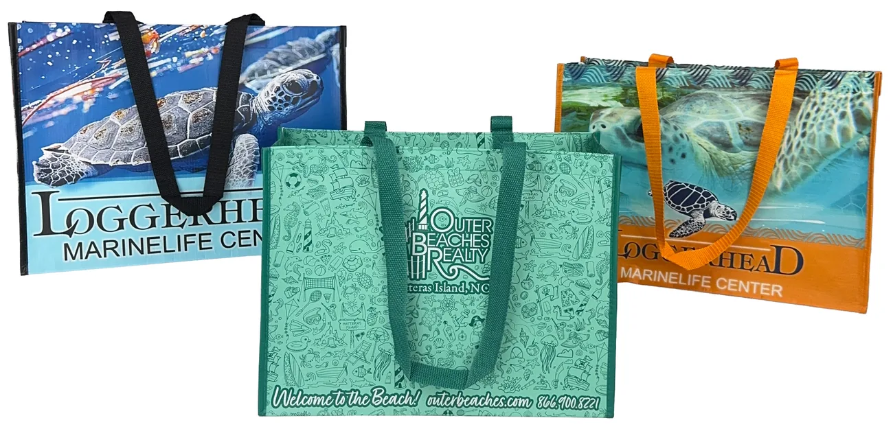 Three custom laminated RPET tote bags printed with sea turtle photographs for a marine life center and a doodle pattern for a beach realty office