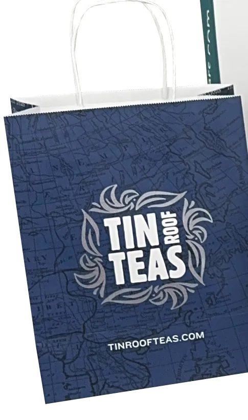 Navy paper shopping bag with an all over print and a white logo