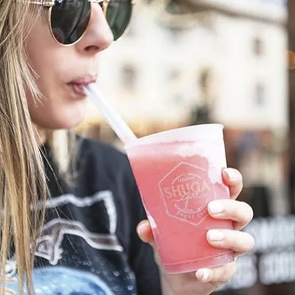 Custom printed clear plastic cup with a pink drink and straw
