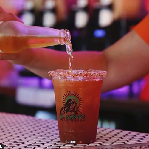 Custom printed clear plastic cup being filled at a bar