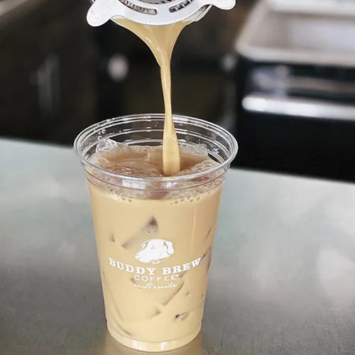 Custom printed clear plastic cup being filled with iced coffee