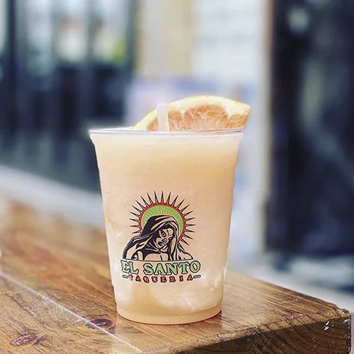 Custom printed clear plastic cup with a frozen orange drink
