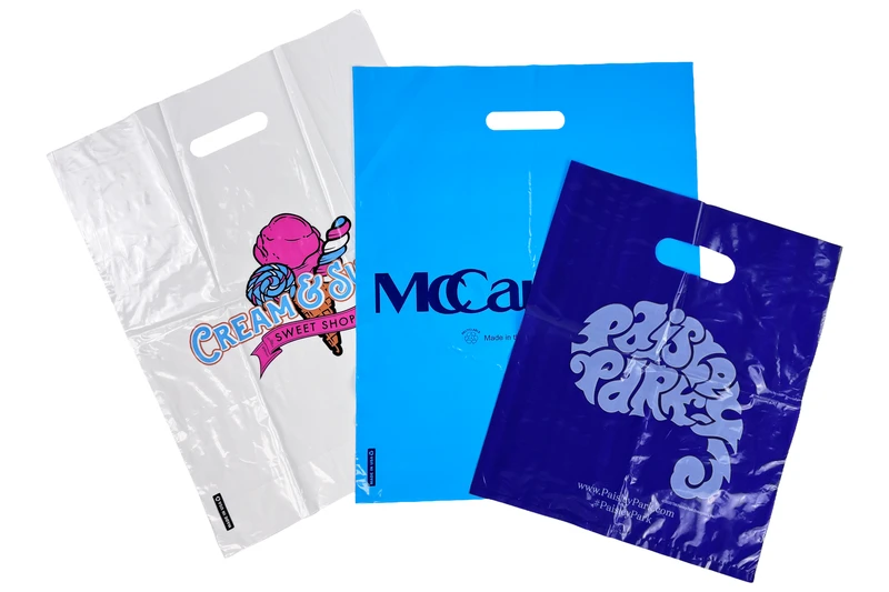 Three custom printed die cut handle plastic bags in clear, light blue and purple film