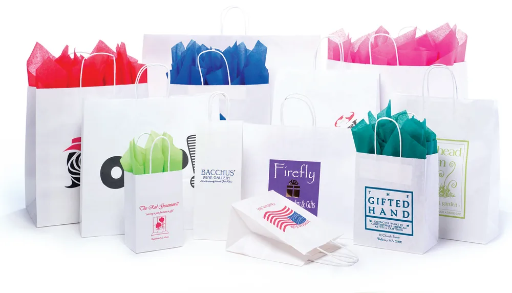 White kraft twisted handle shopping bags in fourteen sizes, ink printed with customer logos and filled with colored tissue