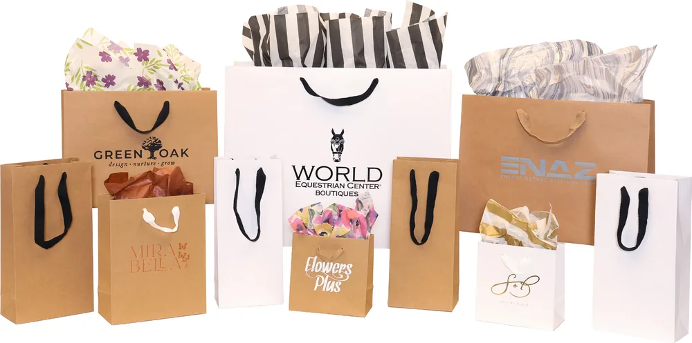 Manhattan totes in heavy kraft and white with black twill handles, hot stamped with logos and filled with tissue
