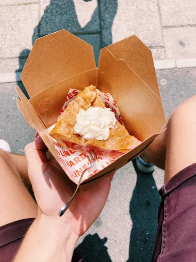 Fried chicken in a take-out box lined with printed wax paper