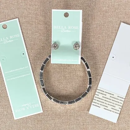 Mint and white combo cards holding earring and bracelet sets with printed boutique logos